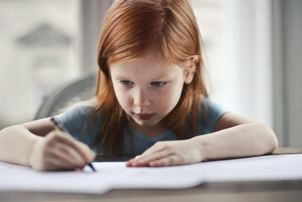 Child practising handwriting with correct pencil grip